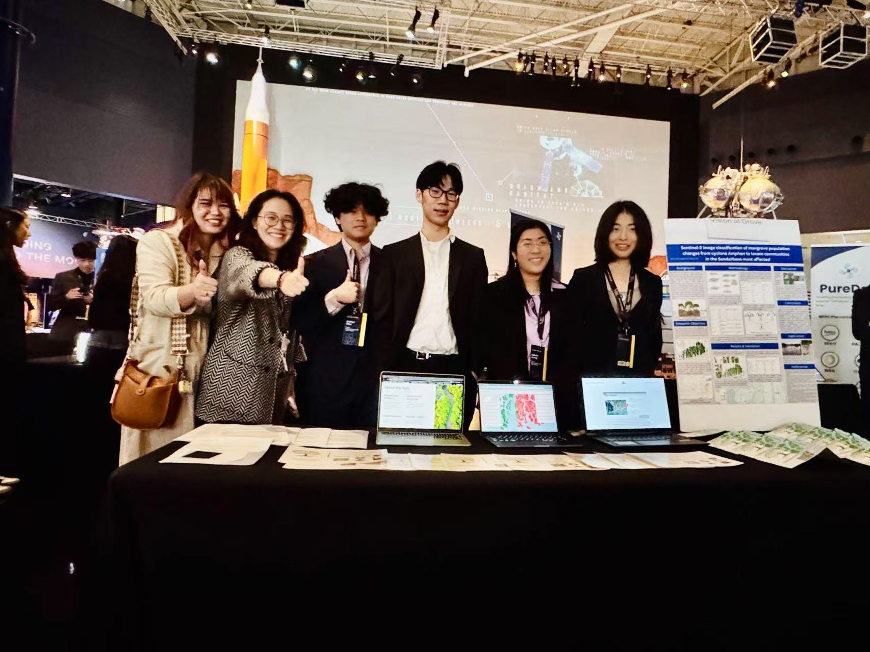 Team at project booth with laptops